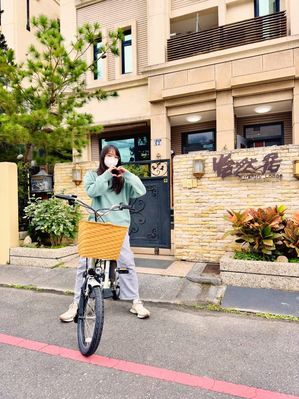 房客騎著怡然居提供的免費自行車,在門口比愛心合影